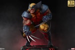 Left-angle view of Wolverine statue on a red-lit base, deeply crouched, highlighting his fierce berserker rage expression, muscles, and iconic claws. (Prototype Shown) View 5