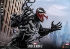 Right side view of Venom with relaxed hands bent at his shoulders, mouth open and tongue out, symbiote tendrils visible, set against a city background. (Prototype Shown) View 9