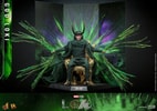 God Loki sitting on a gold throne in iconic horned helmet and attire, with translucent green accents and a menacing expression, set against a green and purple backdrop. Collector Edition (Prototype Shown) View 6