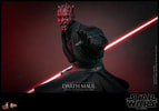 Half body shot of Darth Maul (Collector Edition) showing him in a slight crouch with his left palm extended in front, holding a dual lightsaber pulled back by his right side, with a menacing expression. Collector Edition (Prototype Shown) View 12