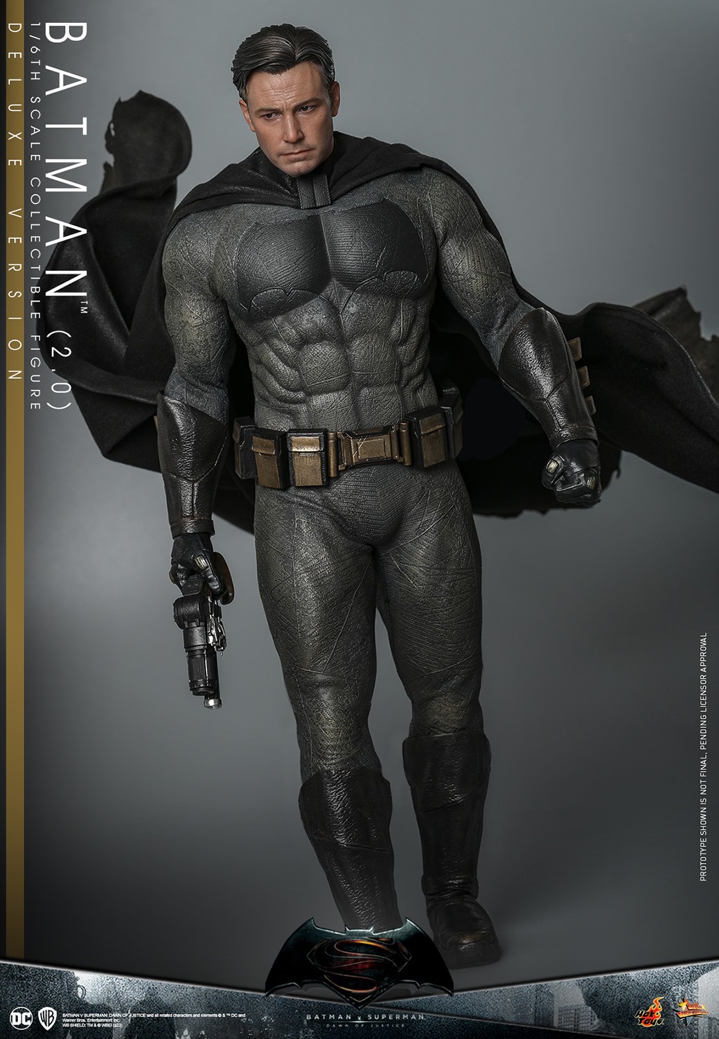 Full-body shot of Batman (2.0) in his full suit, without his cowl, holding a grappler gun in his right hand, showcasing his dynamic pose. (Prototype Shown) View 9