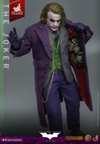 Knee high shot of The Joker (Artisan Edition) opening his topcoat with left hand to reveal weapons, holding a pin and string with his right thumb, and right leg slightly forward. Collector Edition (Prototype Shown) View 8
