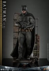 Full action shot of Batman (2.0) in alleyway diorama, leading with his right leg, holding a grenade gun by his abdomen with a focused expression. (Prototype Shown) View 7