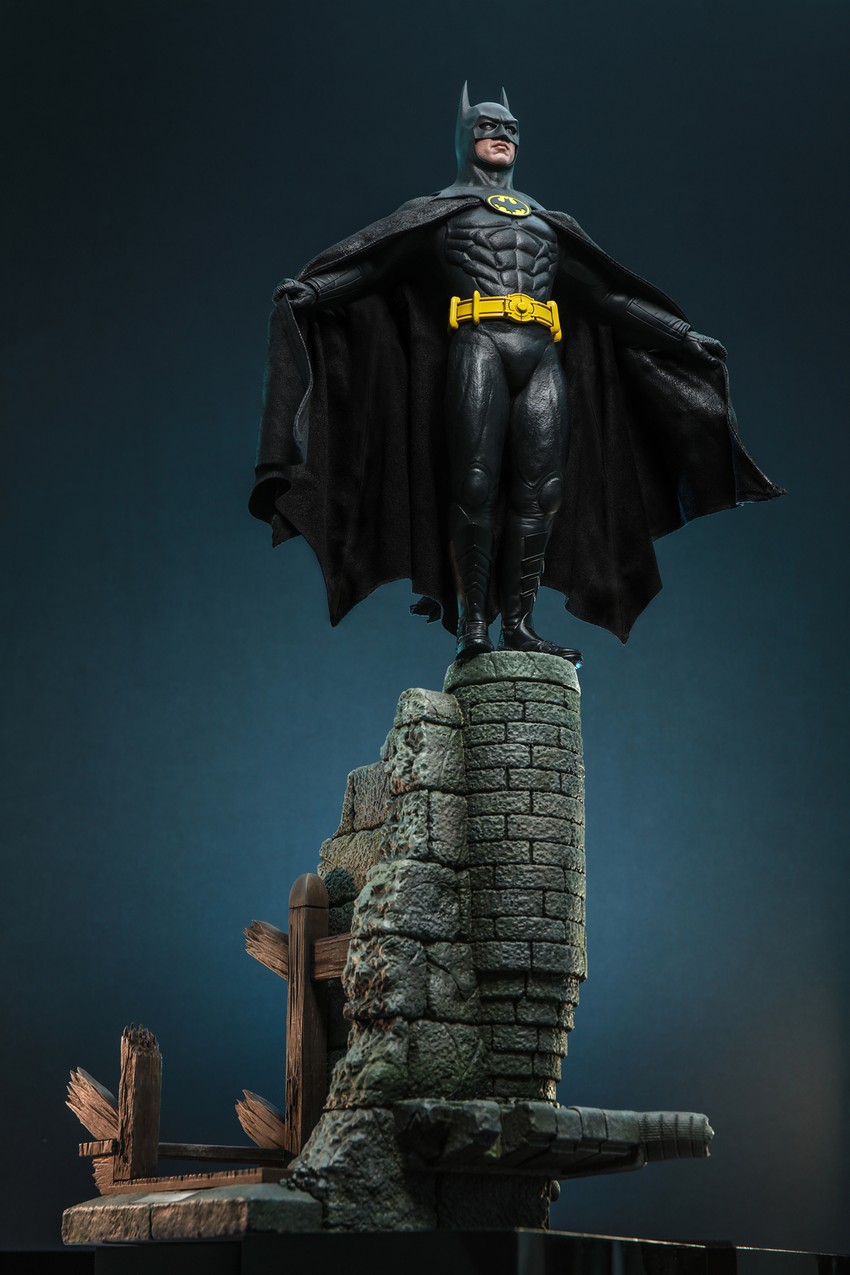 Lower angle shot of Batman (Deluxe Version) standing atop the chapel roof diorama base, holding his cape open with both arms.- Prototype Shown View 6