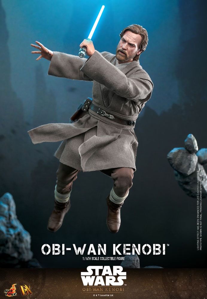 Action shot of Obi-Wan Kenobi mid-air, right knee bent, wielding his blue lightsaber across his face while extending his right palm outward with a focused expression.- Prototype Shown View 6