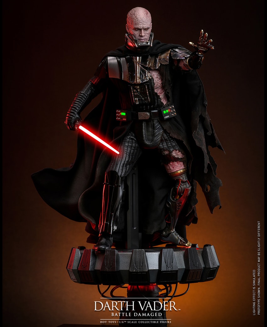 Wide shot of Darth Vader™ (Battle Damaged) unmasked, standing on a display base, holding a lightsaber in his right hand, and extending his mechno left arm.- Prototype Shown View 4